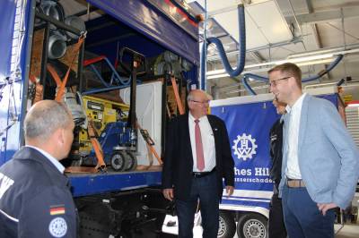 Zugf&uuml;hrer Ingo Sauer (links) erl&auml;utert Kurt Wiegel und Michael Ruhl die Beladung der THW-Lkw 